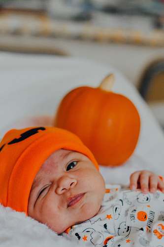 person baby wearing orange knit cap human