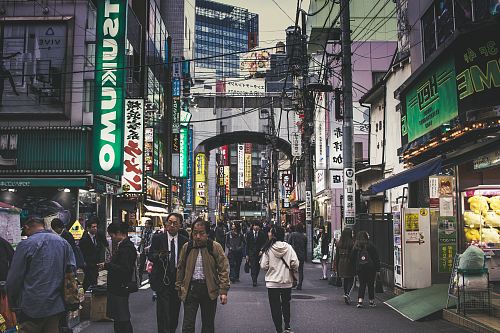 people walking beside gray building during daytime