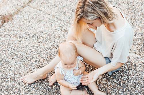 baby woman and a baby sitting on the ground person