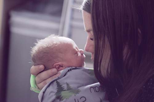 baby woman kissing baby newborn