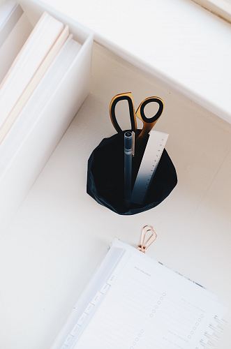 silver ruler and brown safety scissors on pen organizer