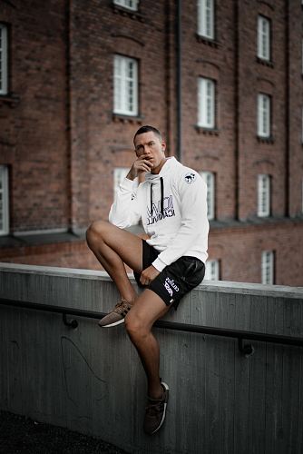 sitting man wearing white pullover hoodie and black shorts during daytime