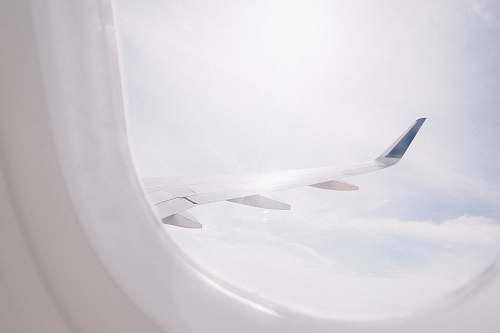 light airplane flying over cloud during daytime blue