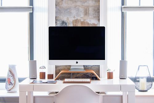 white iMac on top white desk