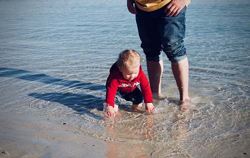 clothing baby standing on body of water pants