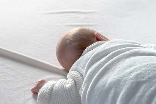 human baby lying on white surface person
