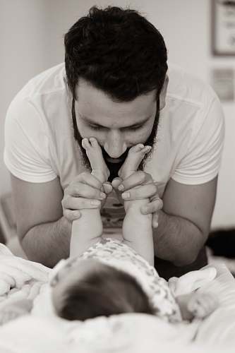 human grayscale photography of man playing with baby person