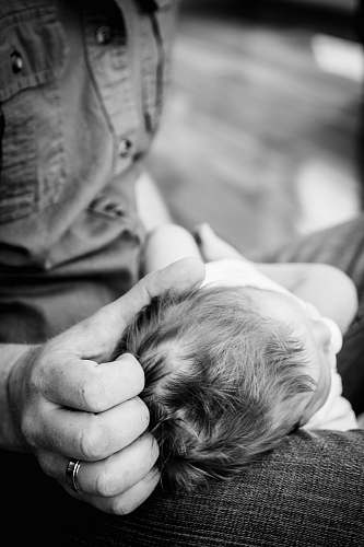 human person with baby on her lap in grayscale photography black-and-white