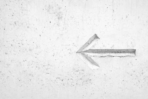grey right arrow sign on wall white