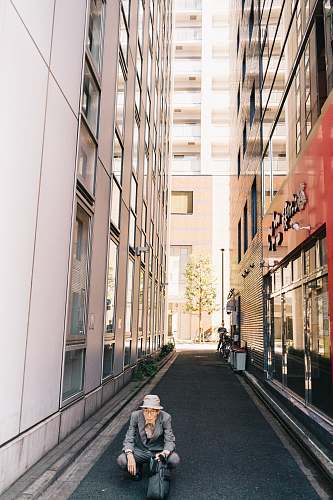 town man sitting near white building street