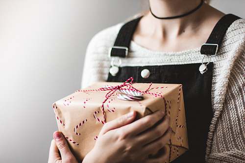 gift close up photography of woman holding grey and red box cologne