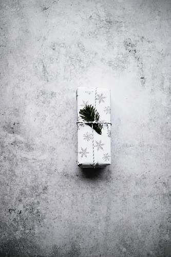 grey white and black snowflake print gift box on gray surface wall