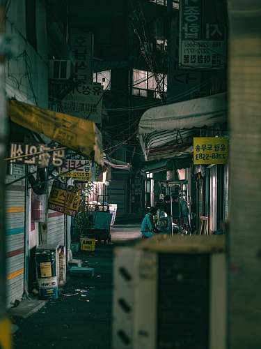 building man sitting front of food stall road