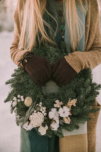 apparel woman holding white and green floral wreath outdoor home decor