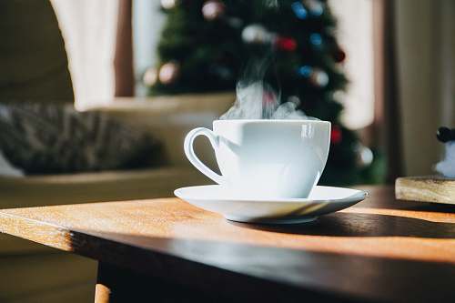table white teacup on top of brown table saucer