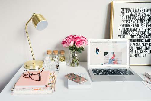 office MacBook Air beside gold-colored study lamp and spiral books blog