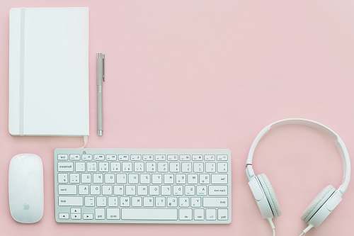 office white Apple Magic Mouse beside of Magic Keyboard and headphones pink