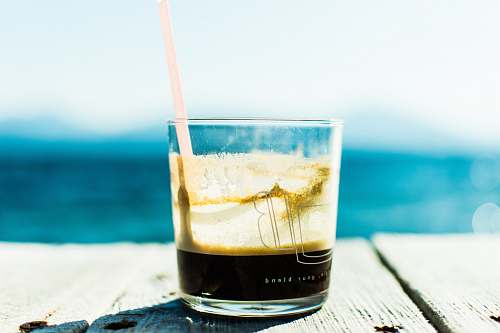 glass 1/4 full clear drinking glass with straw greece