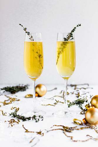 cocktail shallow focus photography of champagne glasses surrounded by gold baubles beverage