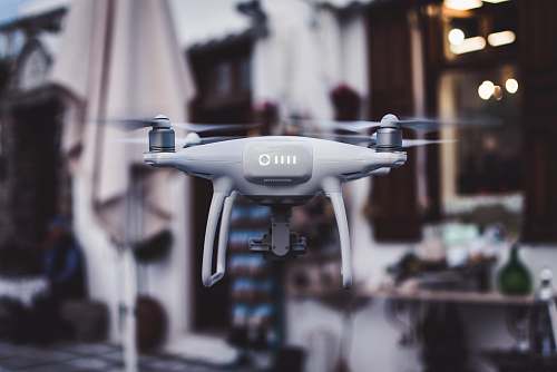 street tilt shift lens photography of gray Phantom drone fly
