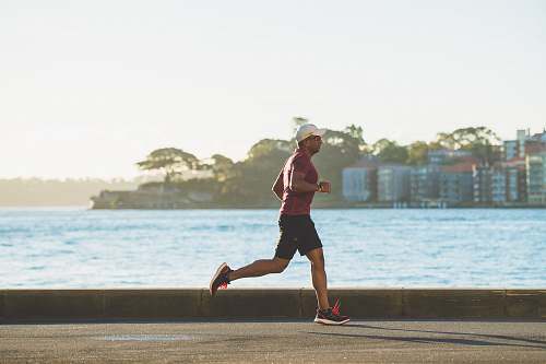 person man running near sea during daytime sports