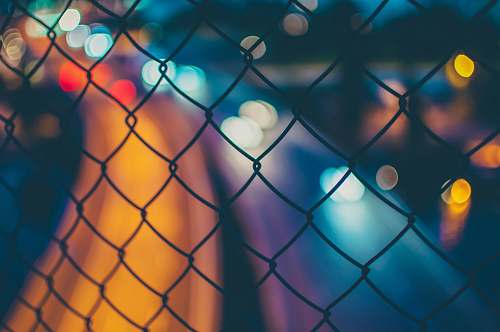 light chain link fence with bokeh lights night