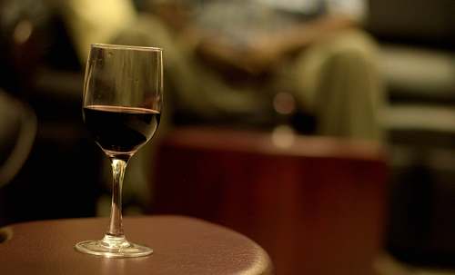 wine shallow focus photography of wine in wineglass on brown wooden table human