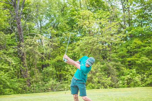 sport man playing golf near green trees during daytime sports