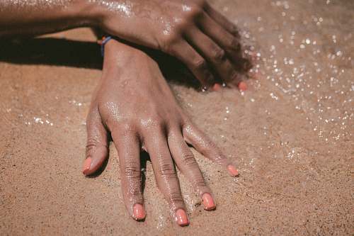 sand person hand showing nail polish nail