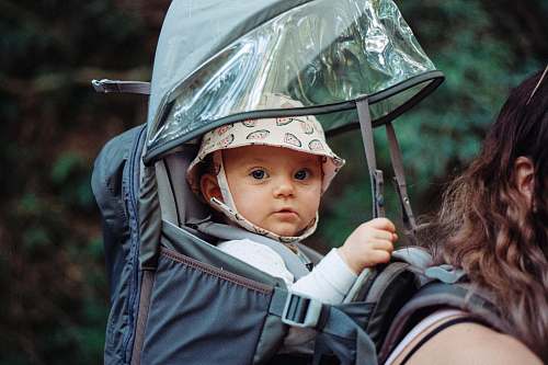 person baby inside black backpack carrier people