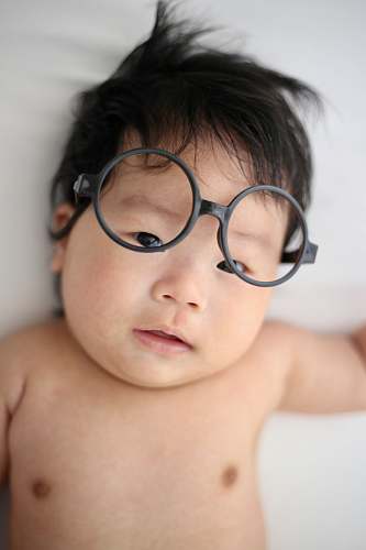 person baby lying on white cloth face
