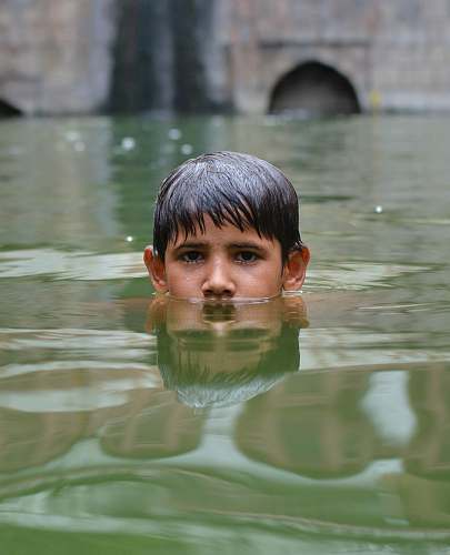 water boy swims in body of water swimming