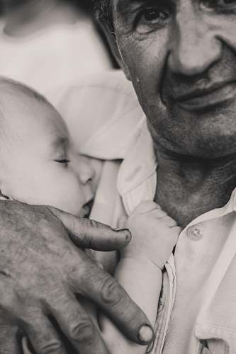 person grayscale photography of man holding child grey