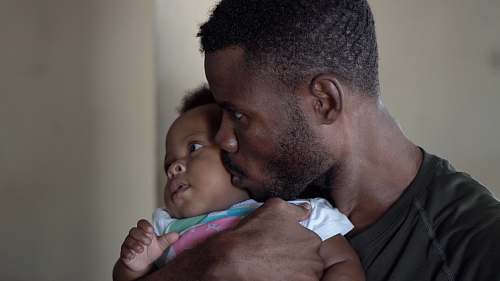 person man carrying baby and kissing face baby