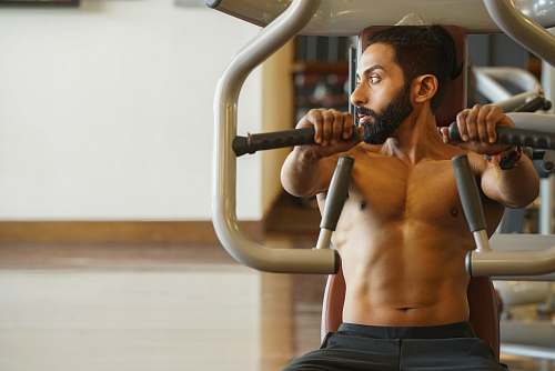 person man sitting on exercise machine working out