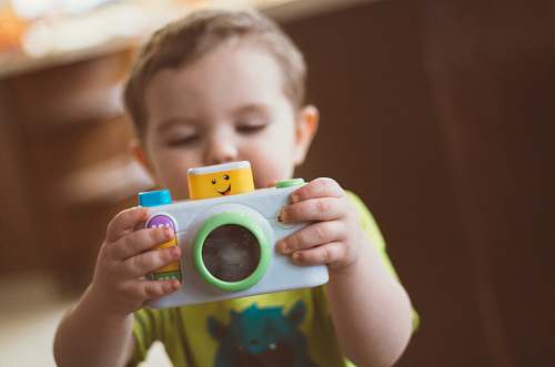 person toddler holding white camera toy people