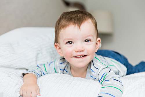 person toddler laying on bed inside room face