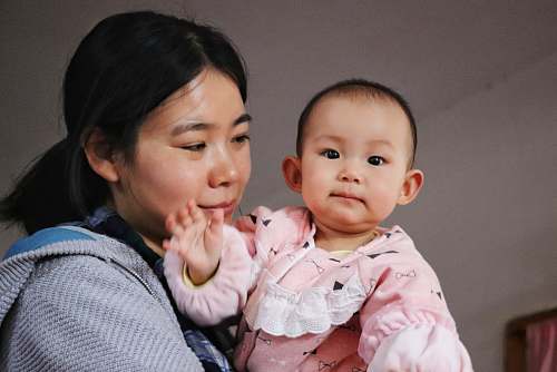 person woman carrying toddler wearing pink clothes people