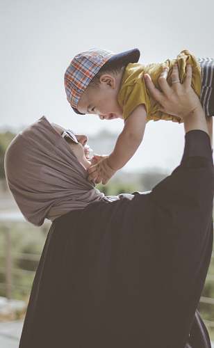 person woman holding boy during daytime people