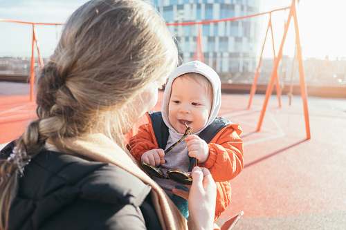 person woman holding toddler on carrier people