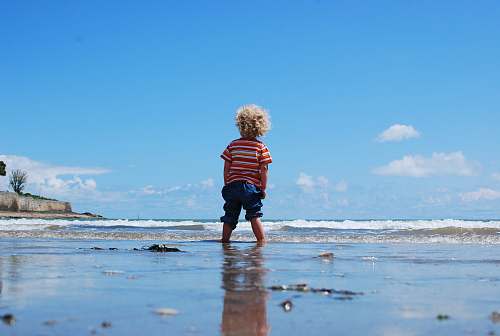 sea child standing on body of water people