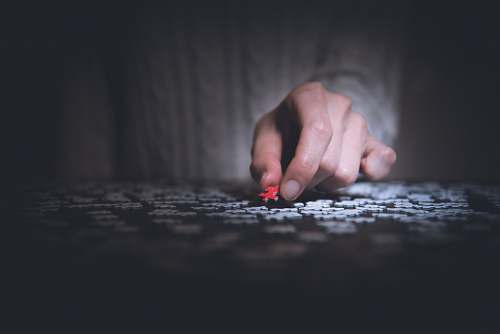human person holding red jigsaw puzzle toe