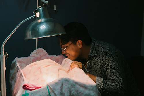 human man standing beside crib person