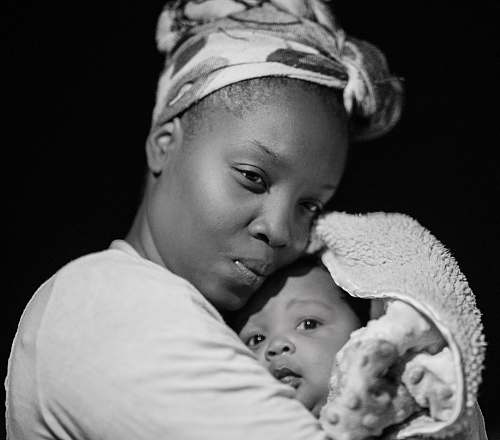 black-and-white grayscale photo of woman carrying baby mother