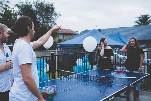 human woman versus man playing beer pong under cloudy sky ping pong