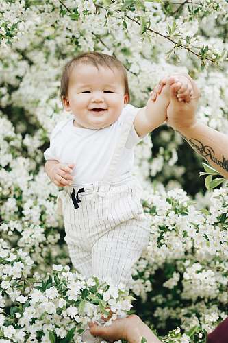 human baby near white petaled flowers skin