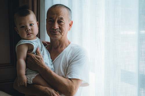 human man carrying baby wearing white shirt baby