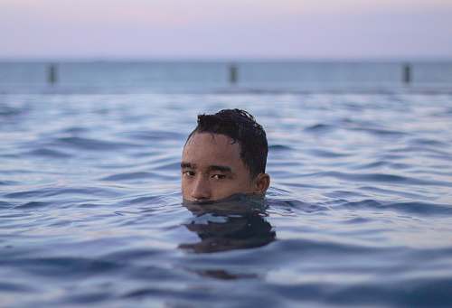 human man swimming in body of water sport