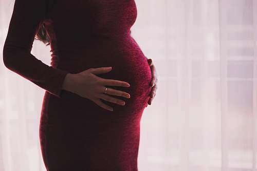 people pregnant woman wearing red long-sleeved dress baby