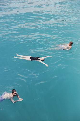 water three people on body of water swimming